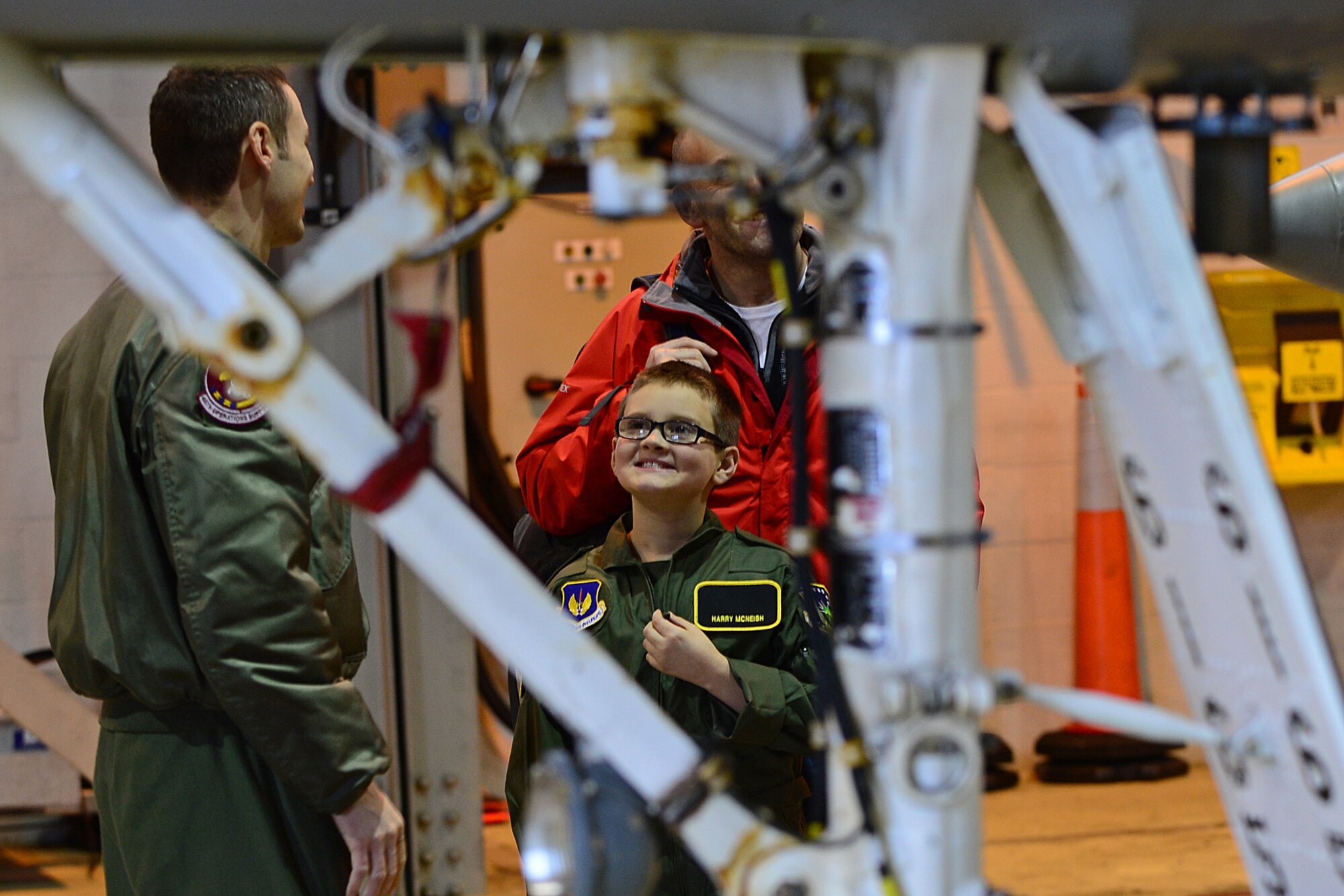 Maj. Jason Bianchi, 48th Operations Support Squadron chief of current operations, shows Harry McNeish, 9, and his father, Christian, an F-15C Eagle up-close during a “Pilot for the Day” event at Royal Air Force Lakenheath, England, Feb. 5, 2014. The program started at RAF Lakenheath in March 2012, to assist children throughout local communities who are fighting life-threatening illness or conditions by providing a day of fun and allowing for a break from the routine doctor and hospital visits. (U.S. Air Force photo by Airman 1st Class Dana J. Butler/Released)