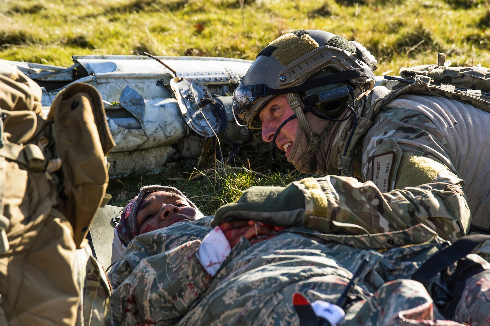 Staff Sgt. Anthony Deroest, 56th Rescue Squadron pararescue specialist, reassures mock victim, Senior Airman Miracle Loveland, 48th Operations Support Squadron intelligence, while under simulated fire from “enemy” forces at the Stanford Training Area, England, Feb. 6, 2014. Airmen participated in four days of training exercises in support of the Air Force’s combat search and rescue mission. (U.S. Air Force photo by Airman 1st Class Nigel Sandridge/Released)