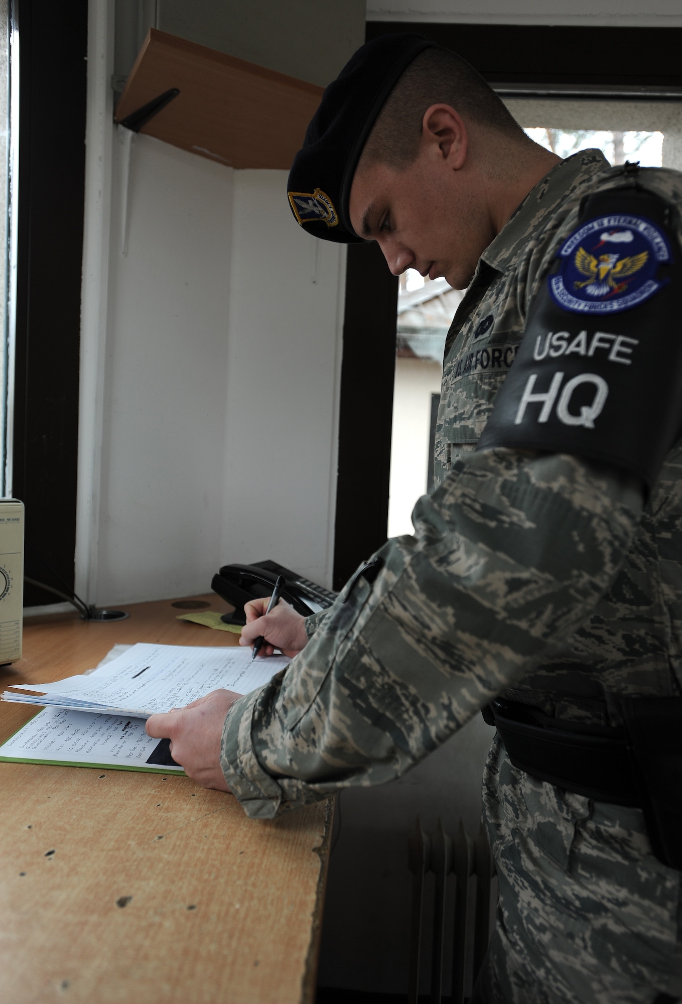 Airman 1st Class Christian Kampe, 86th Security Forces defender, reviews the log book before starting his duty day Feb. 5, 2014, Ramstein Air Base, Germany. Kampe is a first-term Airman who exceedes the expectations set by his leadership by going above and beyond on and off the job. (U.S. Air Force photo/Airman 1st Class Holly Mansfield)