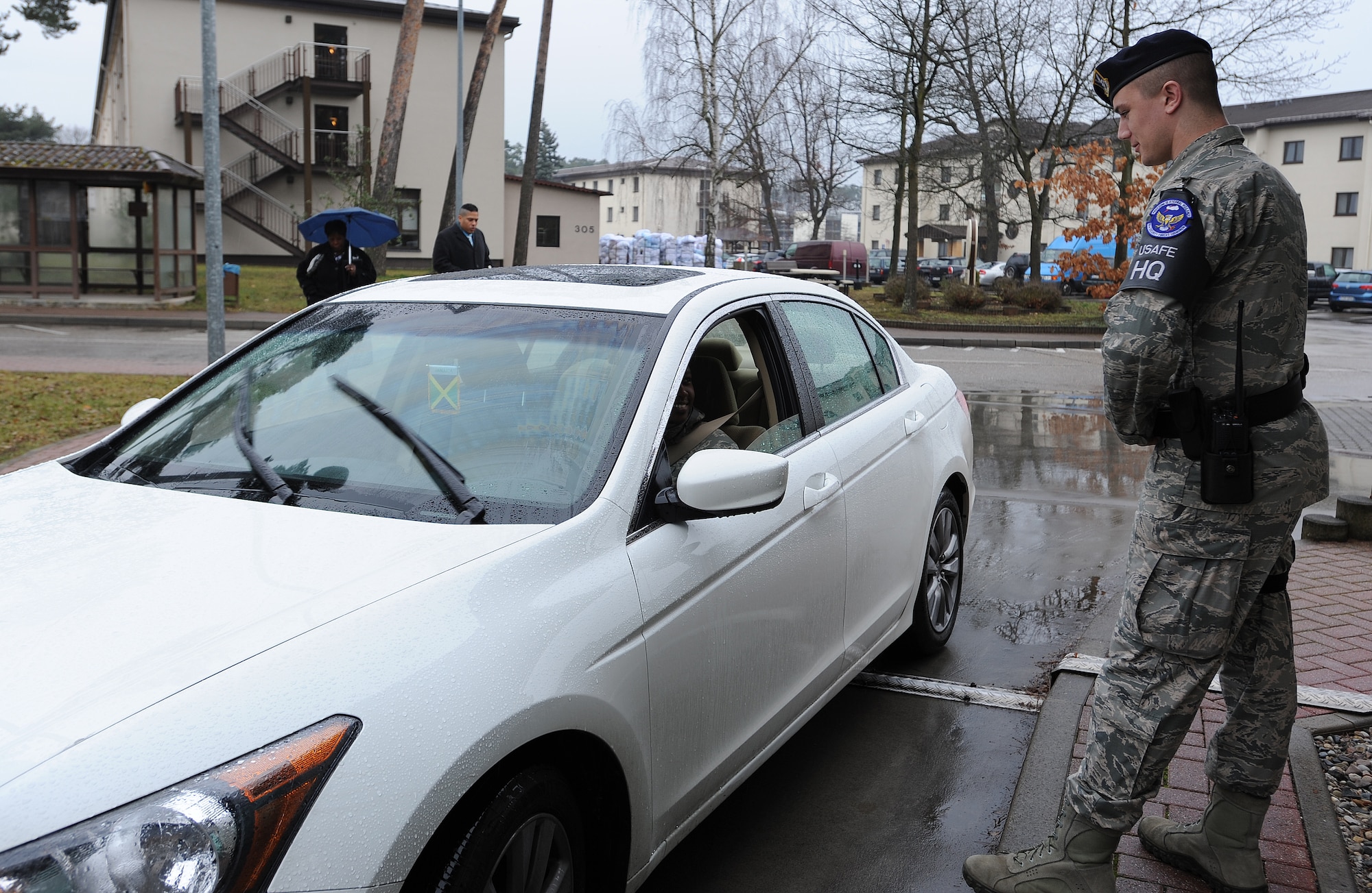 Airman 1st Class Christian Kampe, 86th Security Forces defender, greets a member of team Ramstein at an entry Feb. 5, 2014, Ramstein Air Base, Germany. Kampe is a first-term Airman who exceedes the expectations set by his leadership by going above and beyond on and off the job. (U.S. Air Force photo/Airman 1st Class Holly Mansfield)