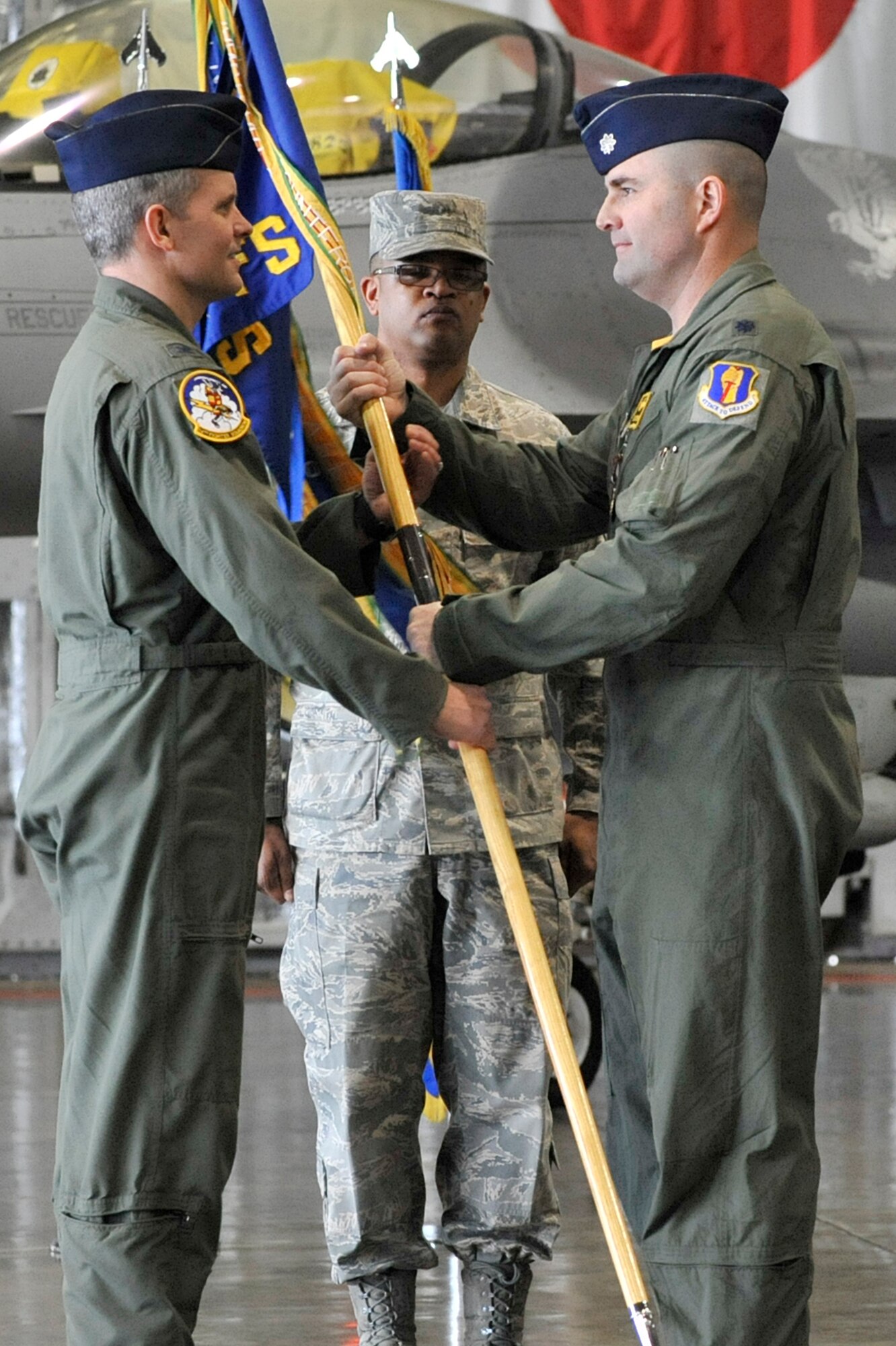 MISAWA AIR BASE, Japan -- Lt. Col. Gene Sherer, right, relinquishes command of the 14th Fighter Squadron to Col. John Parker, 35th Operations Group commander, during a change of command ceremony at Misawa Air Base, Japan, Feb. 7, 2014. Sherer, who has more than 214 combat hours in the F-16 Fighting Falcon, was the 43rd commander to lead the 14 FS. (U.S. Air Force photo/Staff Sgt. Tong Duong.)