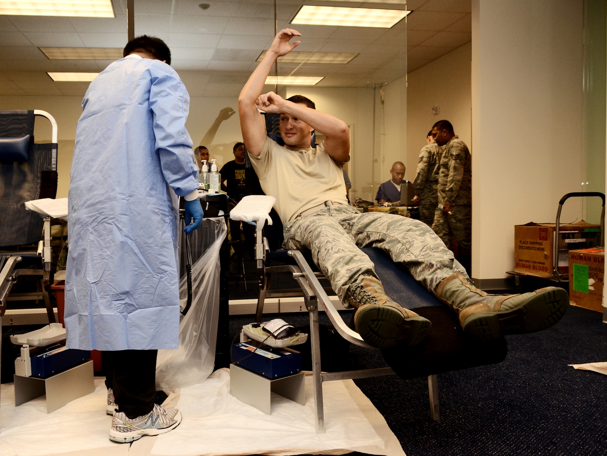 2nd Lt. Andrew Ferris, 36th Contracting Squadron contract administrator, elevates his arm after a U.S. Naval Hospital Guam phlebotomist collects his donation during the 36th CONS sponsored blood drive Jan. 27, 2014, on Andersen Air Force Base, Guam. Each donor gave 500 milliliters of blood to the Armed Services Blood Program for the drive, which will be sent to military medical facilities around the world. (U.S Air Force photo by Airman 1st Class Amanda Morris/Released)