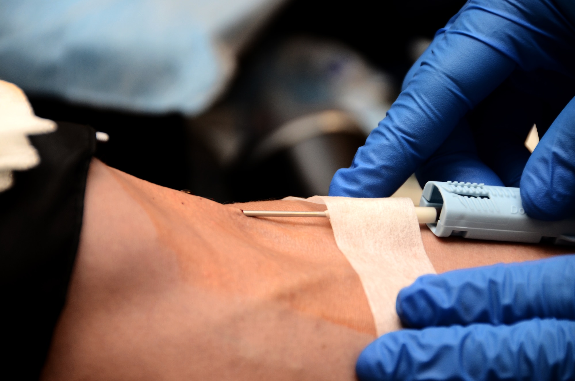 A U.S. Naval Hospital Guam phlebotomist tapes a needle to a blood donors arm at the 36th Contracting Squadron-sponsored blood drive Jan. 27, 2014 on Andersen Air Force Base, Guam. Each donor gave 500 milliliters of blood to the Armed Services Blood Program for the drive, which will be sent to military medical facilities around the world. (U.S Air Force photo by Airman 1st Class Amanda Morris/Released)