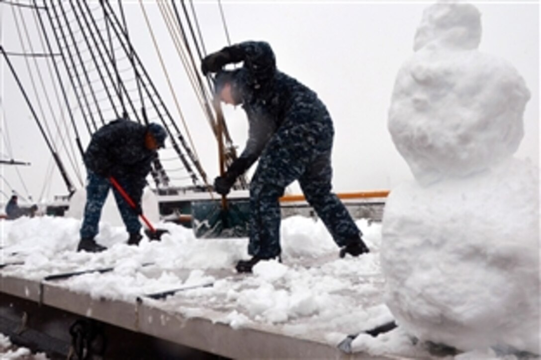 U.S. Navy Petty Officer 2nd Class Gilbert Caine, left, and Petty Officer 2nd Class Randall King shovel snow off the main hatch cover aboard USS Constitution during a snowstorm in Charlestown, Mass., Feb. 5, 2014. The greater Boston area averages 43.8 inches of snow accumulation each winter, and Constitution crew members are responsible for keeping the decks of 'Old Ironsides' snow and ice-free.