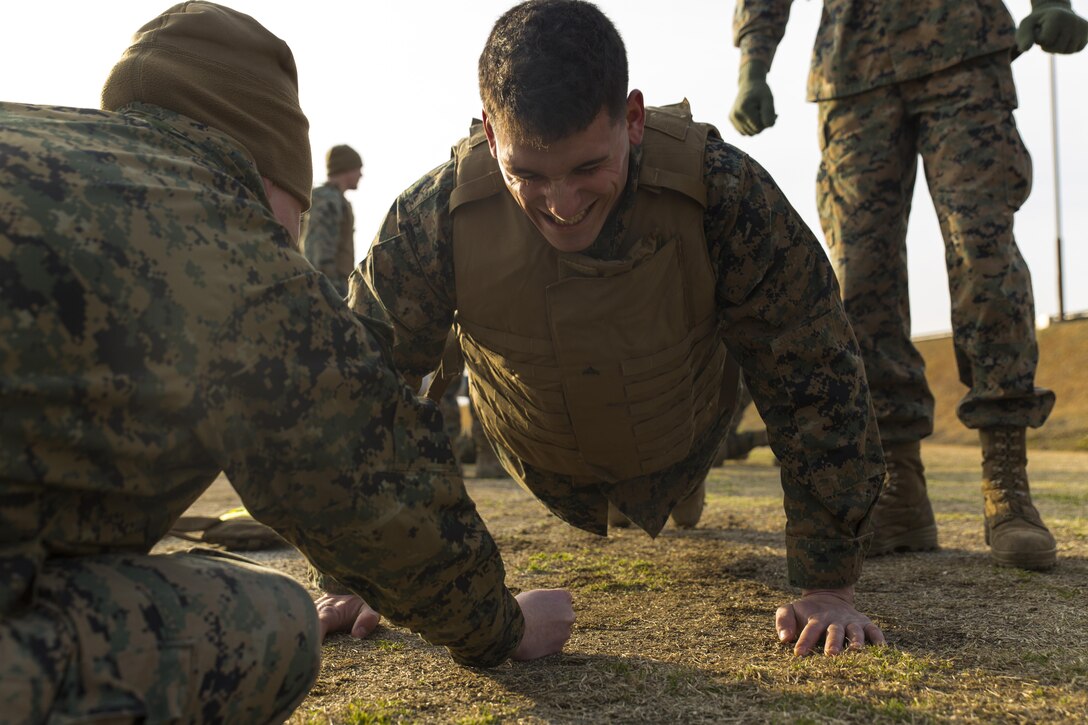 Lance Cpl. Chase Leake, an aircraft recovery crew member with Headquarters and Headquarters Squadron, does push-ups at the obstacle course for the Ironman Competition aboard Marine Corps Air Station Iwakuni, Japan, Feb. 5, 2014. The competition had 11 teams participate, and the Provost Marshals’ Office team emerges as the victors. 