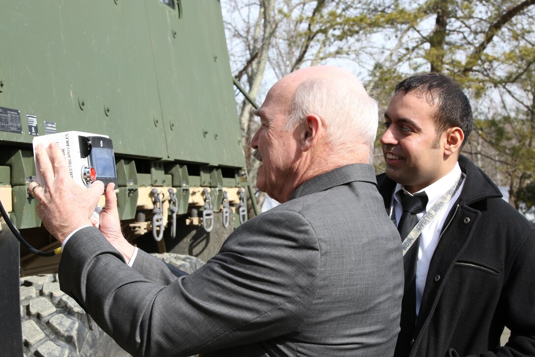 Dennis McGinn, the assistant secretary of the Navy for energy, installations and environments, operates the Medium Tactical Vehicle Replacement Auxiliary Power Unit, a generator in development, during a tour of Marine Corps Base Quantico on Feb. 6, 2014. The MTVR-APU is more efficient than other generators and could save the Marine Corps almost 60 percent on fuel. 