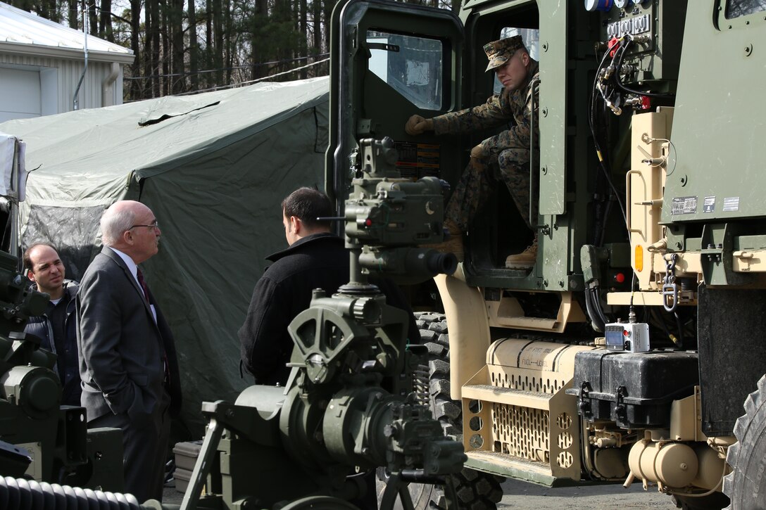 Dennis McGinn, the assistant secretary of the Navy for energy, installations and environments, is briefed on the Medium Tactical Vehicle Replacement Auxiliary Power Unit, a new generator in development, during a tour of Quantico on Feb. 6, 2014. The MTVR-APU is more efficient than other generators and could save the Marine Corps almost 60 percent on fuel. 