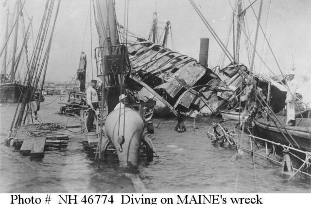 U.S. Navy diving crew at work on the ship's wreck, in 1898, seen from aft looking forward. U.S. Naval Historical Center Photograph # NH 46774.