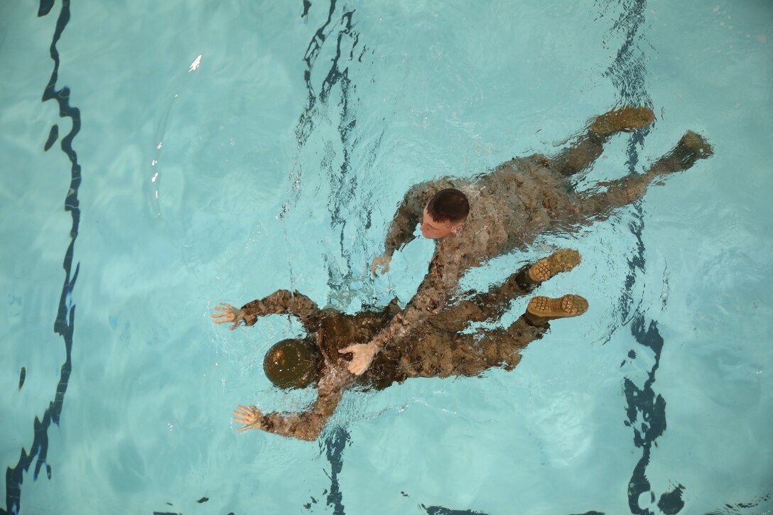 Second Lt. Sara Shannon, a student at The Basic School, pretends to drown as Staff Sgt. Charles Martin, an infantry unit leader with The Basic School, rescues her at Ramer Hall on Feb. 5, 2014. Henry and Shannon were participating in Water Survival Advance qualification course.
