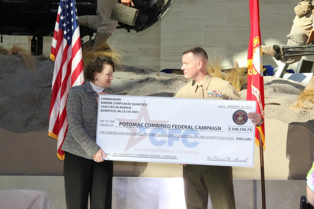 Col. David Maxwell, commanding officer of Marine Corps Base Quantico, presents a check to Janel Donohue, president of the Rappahanock United Way at the National Musuem of the Marine Corps on Jan. 29, 2014. Nine units received awards during the ceremony for their participation with the 2013 campaign.