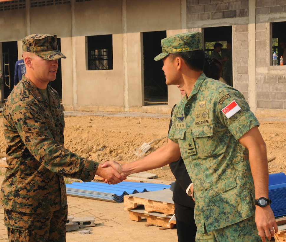 Singapore army Brig. Gen. Desmond Tan (right) acknowledges the hard work of U.S. Marine Corps 1st Lt. James Woolley, the site officer in charge, and the site’s multinational team during his visit to Tabaek Ngam School in Phitsanulok province, Kingdom of Thailand, Feb. 10, 2014. The school is one of four locations supported by Exercise Cobra Gold 2014, a Thai-U.S. co-sponsored exercise committed to improving regional partnership, prosperity and security in the Asia-Pacific region. Tan is the chief guards officer and commander of the 21st Division. Woolley is with Engineer Company, Marine Wing Support Squadron 171, Marine Aircraft Group 12, 1st Marine Aircraft Wing, III Marine Expeditionary Force.