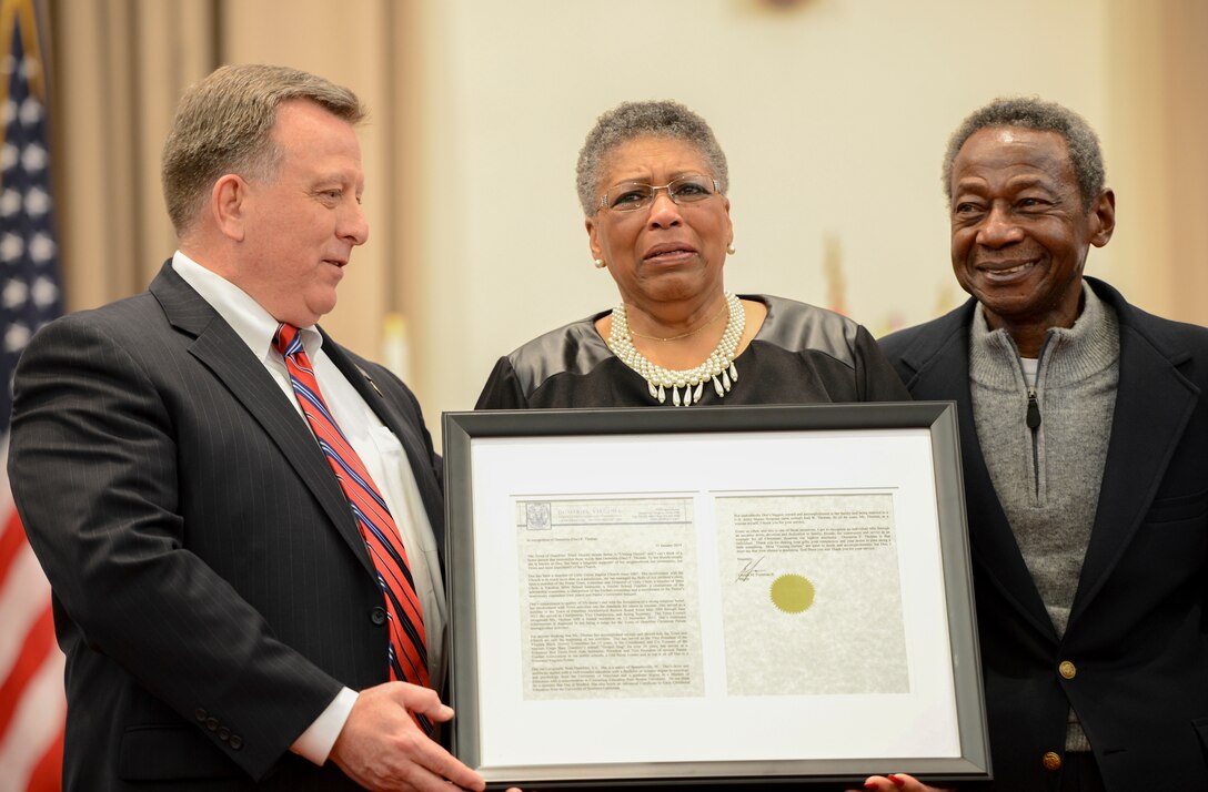Demetria Thomas, center, holds back tears as she is presented a citizens award by Gerald Foreman, left, mayor of the town of Dumfries, at the Marine Memorial Chapel aboard Marine Corps Base Quantico during the 20th Annual Gospel Sing on Feb. 8, 2014. Thomas has been a constant presence in the community on and off base for many years.