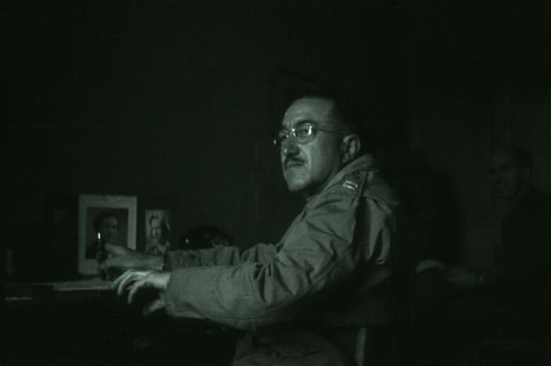 Ralph W. Hammett sits at a desk during World War II. At this time Hammett held the rank of Captain.