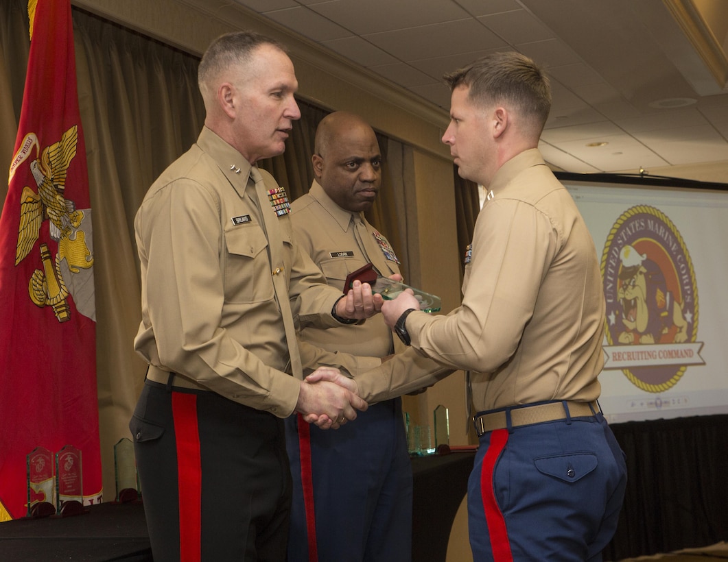 Captain Martin E. Lindig, Officer Selection Officer (OSO), Officer Selection Station College Station, receives the Captain Samuel Nicholas Globe and Anchor award from Maj. Gen. Mark A. Brilakis, Commanding General, Marine Corps Recruiting Command (MCRC), at the National Operations and Training Symposium (NOTS), here today. The Capt. Samuel Nicholas Globe and Anchor award is given to Officer Selection teams who met their assigned mission during the previous year. During FY 13, 60 OSOs achieved their assigned mission.
