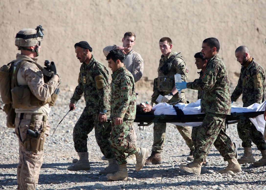 Petty Officer 3rd Class Kristopher Krysa, center, 27, from La Grange Park, Ill., a corpsman with Security Force Assistance Advisor Team 2-215, directs a casualty evacuation on an Afghan National Army base near Forward Operating Base Nolay, Helmand province, Afghanistan, Jan. 28, 2014. Krysa was recently selected as the Regional Command (Southwest) and Brigade Headquarters Group-Afghanistan SFAAT Junior Sailor of the Quarter.