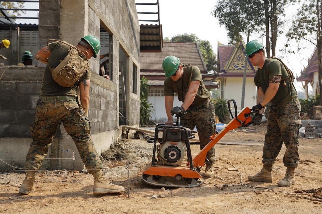 From left to right, U.S. Marine Corps Lance Cpl. Stan Wright, Cpl. Andrew O'Malley and Lance Cpl. Patrick Thompson, engineers with the 9th Engineer Support Battalion, 3rd Marine Logistics Group, III Marine Expeditionary Force, start up a compactor on a school construction site in Muang, Phitsanulok, Kingdom of Thailand Feb. 10, 2014 in support of Exercise Cobra Gold 2014. CG 14, in its 33rd iteration, demonstrates the U.S. and the Kingdom of Thailand's commitment to their long-standing alliance and regional partnership, prosperity and security in the Asia-Pacific region.
