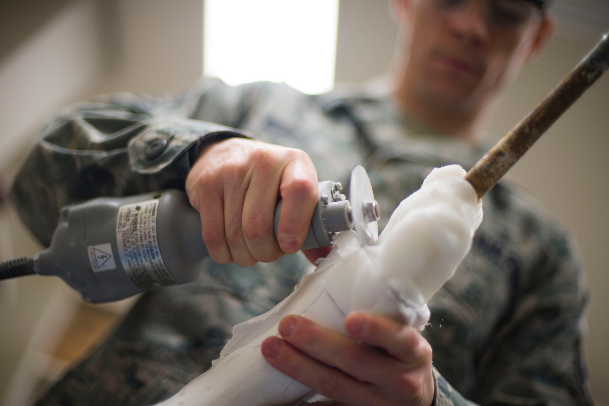 Staff Sgt. Russell Weber, 374th Surgical Operations Squadron NCOIC of Orthotics, cuts open a mold at Yokota Air Base, Japan, Feb. 12, 2014. Orthotics personnel specialize in creating braces and inserts for several types of injuries. (U.S. Air Force photo by Staff Sgt. Chad C. Strohmeyer/Released)