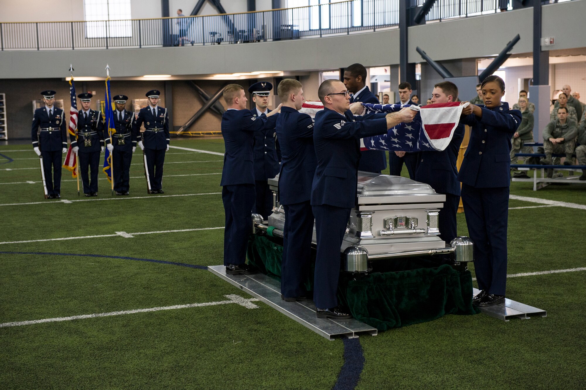 Members of the base honor guard team fold a flag during a mock military funeral with honors Feb. 7, 2014, Eielson Air Force Base, Alaska. Twelve new members went through 40 hours of training which included pall bearing, firing team, colors, proper wear of the ceremonial dress and the importance of military customs and courtesies. (U.S. Air Force photo by Senior Airman Joshua Turner/Released)