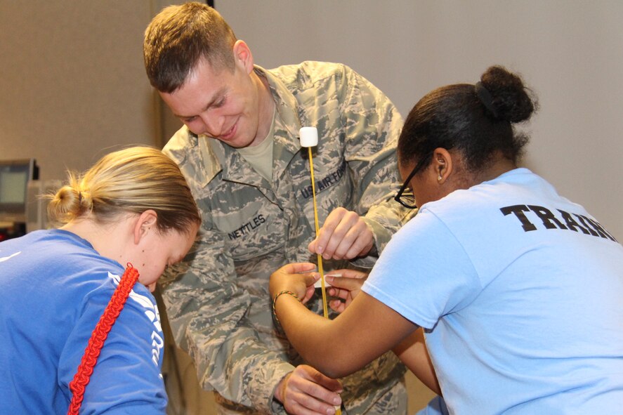 Newly enlisted members of the 932nd Airlift Wing's development and training flight work together to create a structure out of household materials as part of a team building exercise during the unit training assembly. Master Sgt. Dana Crockett the program director for the DTF program said it helps new members get acclimated to the military environment and prepares them for basic military training. (Air Force photo/by Staff Sgt. Meiko Schill) 