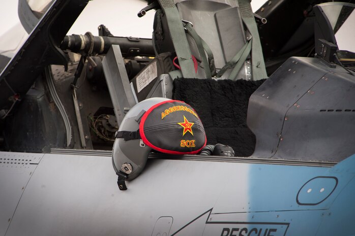 A 64th Aggressor Squadron helmet sits on an F-16 Fighting Falcon aircraft Feb. 6, 2014, at Nellis Air Force Base, Nev. To provide a realistic training scenario during Red Flag, the 64th AGRS’s aircraft paint schemes are inspired to replicate near peer adversaries markings and insignias. (U.S. Air Force photo by Lorenz Crespo)