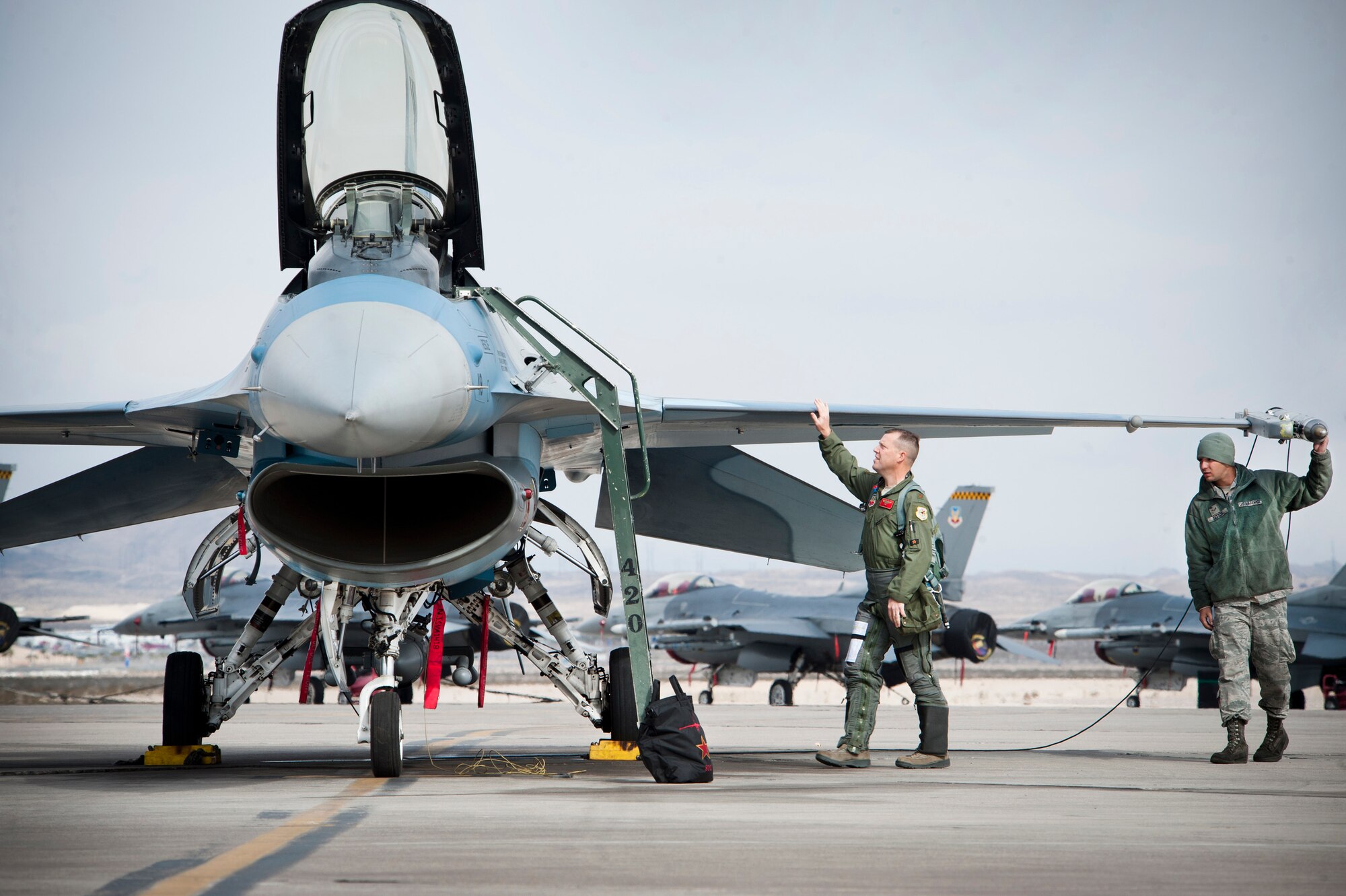 Airman 1st Class Jonathon Sitsis, 57th Aircraft Maintenance Squadron Viper Aircraft Maintenance Unit dedicated crew chief, and Maj. Scott Jewell, 64th Aggressor Squadron pilot, perform a pre-flight inspection on the F-16 Fighting Falcon during Red Flag 14-1 Feb. 6, 2014, at Nellis Air Force Base, Nev.  During Red Flag, the 64th AGRS replicate threats joint and allied combat air forces might face anywhere in the world. (U.S. Air Force photo by Lorenz Crespo)