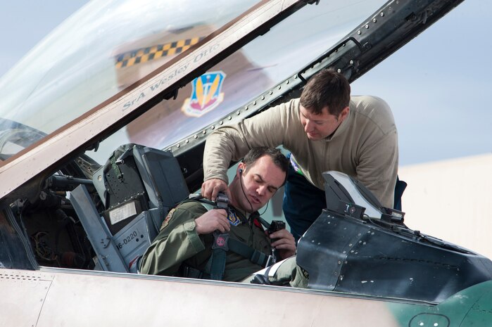Staff Sgt. Bradley Schuster, 57th Aircraft Maintenance Squadron Viper Aircraft Maintenance Unit dedicated crew chief, assists Maj. Ryan Howland, 64th Aggressor Squadron F-16 pilot, into the cockpit prior to a Red Flag 14-1 training mission Feb. 6, 2014, at Nellis Air Force Base, Nev. Red Flag provides Airmen an opportunity to experience contested, degraded and operationally limited combat situations in a controlled environment to increase their ability to complete missions and safely return home. (U.S. Air Force photo by Lorenz Crespo)