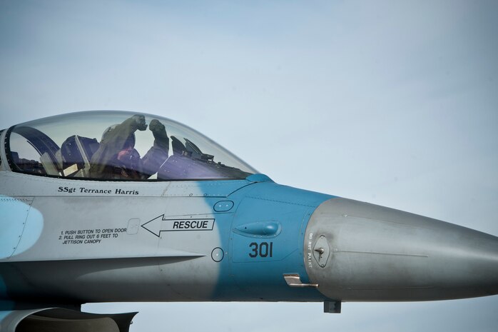 Maj. Ryan Howland, 64th Aggressor Squadron pilot, taxis his F-16 Fighting Falcon to the active runway and displays his squadron’s hand signal prior to a Red Flag 14-1 training mission Jan. 29, 2014, at Nellis Air Force Base, Nev. The 64th AGRS motto is “Know, Teach and Replicate.” During Red Flag they challenge joint and allied aircrews with training scenarios in the same way adversary air forces would do in a real conflict or war. (U.S. Air Force photo by Lorenz Crespo)