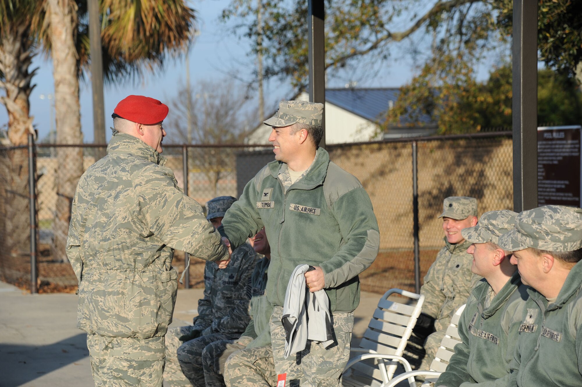 Master Sgt. Roger Pursley, 334th Training Squadron battlefield Airmen training superintendent, passes on a training T-shirt to Col. George Tombe, 81st Training Group commander, during the heated triangle pool ribbon cutting ceremony Feb. 7, 2014, at Keesler Air Force Base, Miss.  The heated pool will allow Keesler’s battlefield Airmen students the ability to execute water skills training without impeding on the limited time the students have in the morning for physical training before starting their academic day.  Prior to the heater being installed, the Airmen had to use an off base facility.  (U.S. Air Force photo by Kemberly Groue)