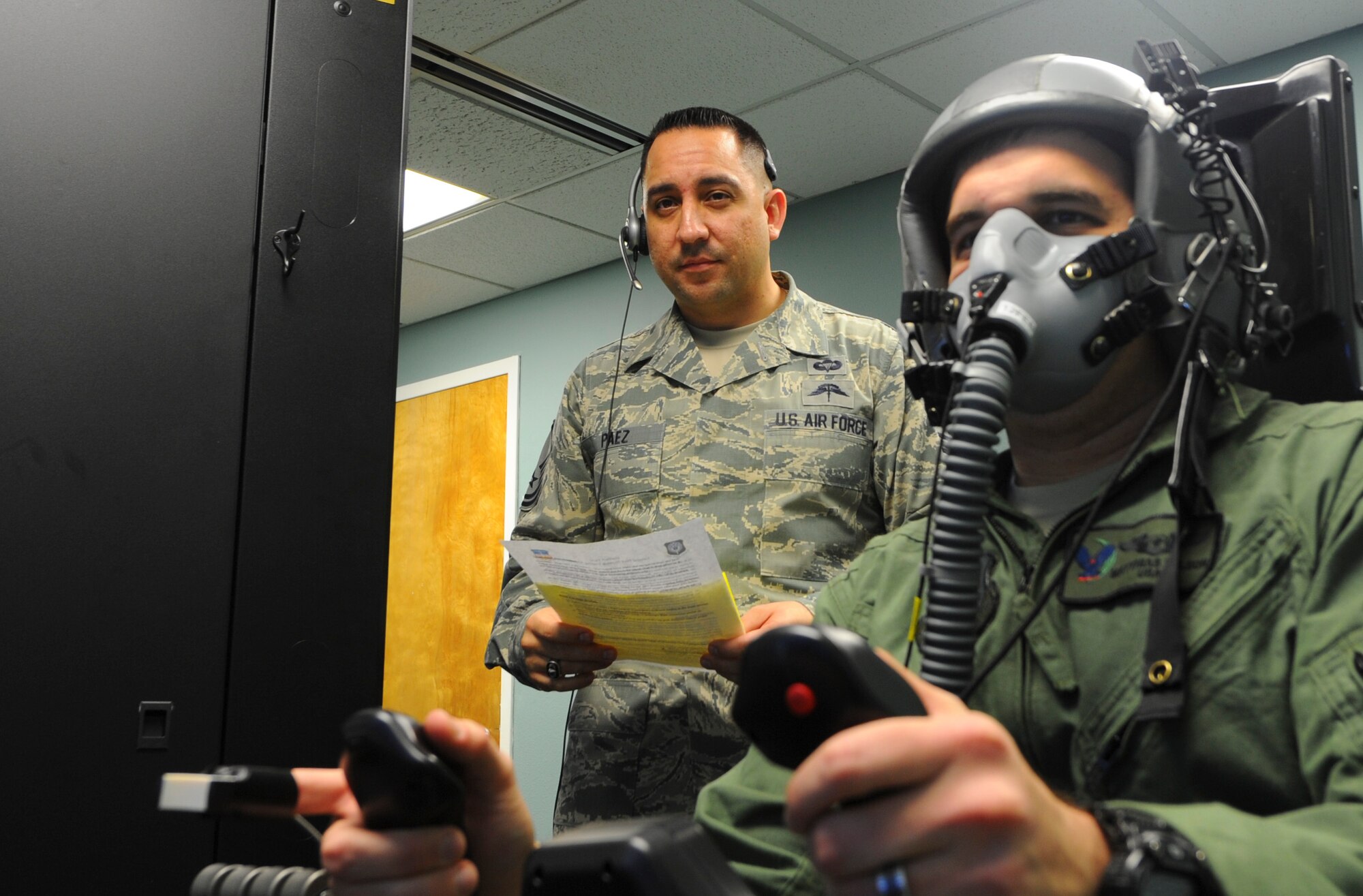 Master Sgt. Ismael Paez, 1st Special Operations Support Squadron Air Force Special Operation Command functional manager, conducts refresher physiological hypoxia training with Capt. Mathias Wilson, 9th Special Operations Squadron navigator, at Hurlburt Field, Fla., Feb. 4, 2014. The Reduced Oxygen Breathing Device allowed Paez to simulate flight at 25,000 feet and induce Hypoxia, which occurs when the body is deprived of oxygen. (U.S. Air Force photo/Airman 1st Class Jeff Parkinson)