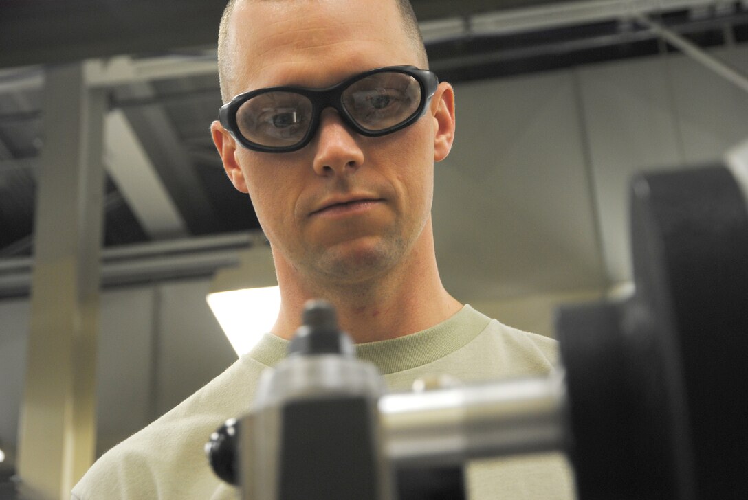Staff Sgt. Edward James Broz, 69th Maintenance Squadron aircraft metals technology craftsman, monitors a metal bushing being made on a metal lathe Feb. 7, 2014, at his workshop on Grand Forks Air Force Base, N.D. A lathe is a machine tool which rotates the work-piece on its axis to perform various operations such as cutting, sanding, knurling, drilling, or deformation. (U.S. Air Force photo/Staff Sgt. Luis Loza Gutierrez)  
