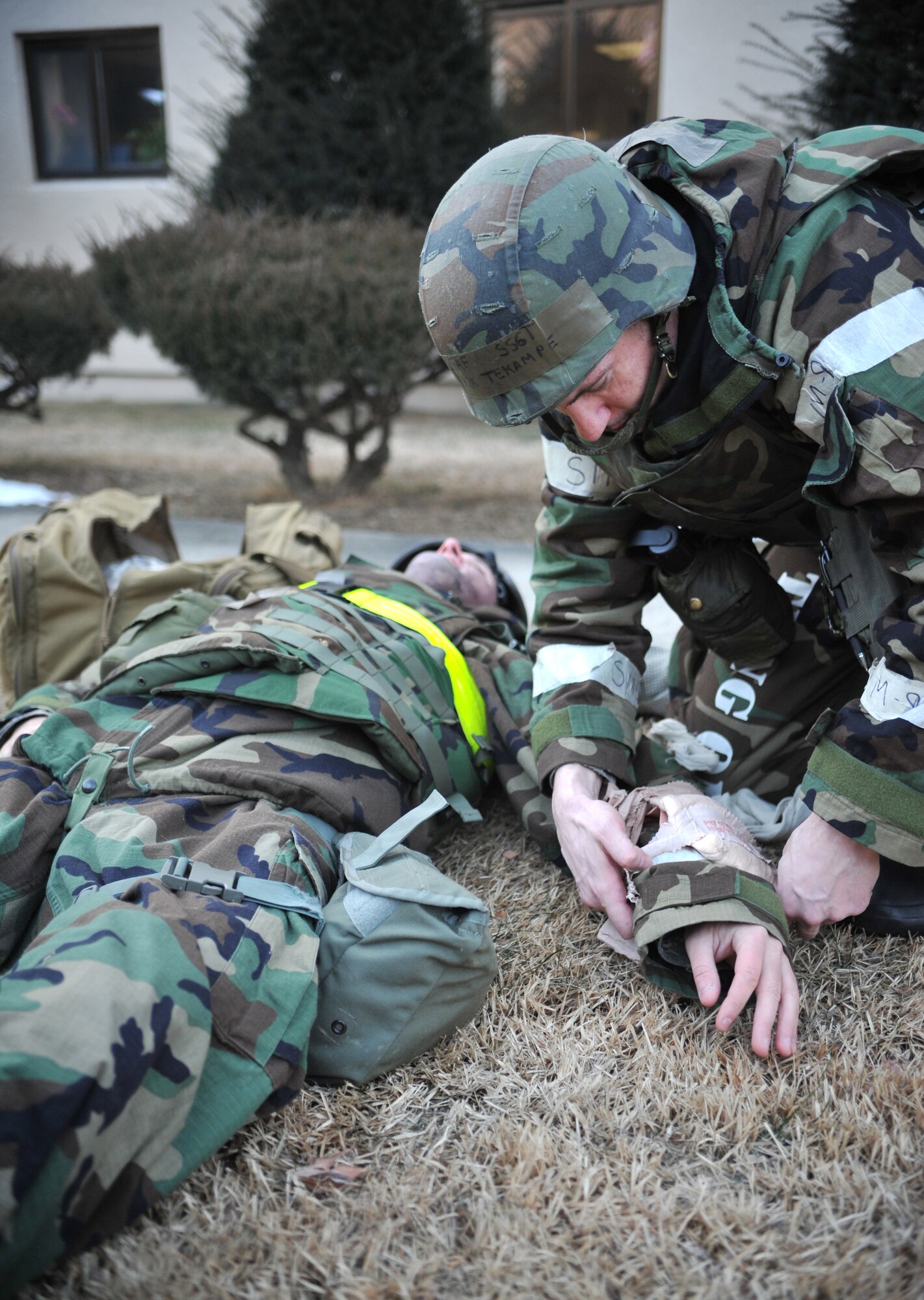 Staff Sgt. Derek Tekampe, 51st Comptroller Squadron post-attack reconnaissance team member, places an emergency bandage on a simulated casualty’s mock arm laceration as part of a mass casualty scenario outside Bldg. 938 during Operational Readiness Exercise Beverly Midnight 14-02 at Osan Air Base, Republic of Korea, Feb. 11, 2014. In both ORE scenarios and real-world situations, PAR teams not only search the area for unexploded ordnances but also for casualties and must then perform self aid and buddy care until additional medical personnel arrive. (U.S. Air Force photo/Airman 1st Class Ashley J. Thum)