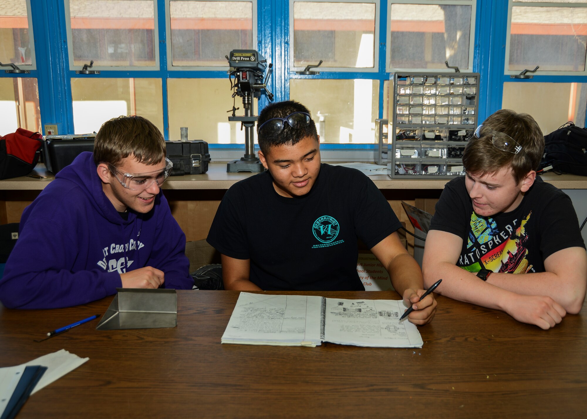 (left to right) Co-captain, Larson LeDuc, Team member, Anthony Quinnert and Team captain, Geoffrey Holmes, grade 12, study their engineering notebook.  (U.S. Air Force photo by Rebecca Amber)