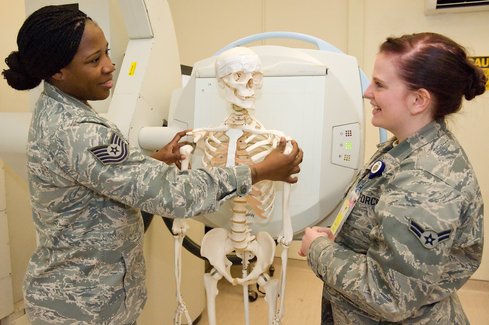 Tech. Sgt. Aisha Toston, 436th Medical Support Squadron diagnostics imaging technician, instructs Airman 1st Class Kylie Sisson, 436th Medical Operations Squadron on patient positioning Feb. 11, 2014, at the clinic on Dover Air Force Base, Del. Toston won the 2013 Air Mobility Command Outstanding Air Force Diagnostics Imaging Technician Noncommissioned Officer of the Year award. (U.S. Air Force photo/Roland Balik)
