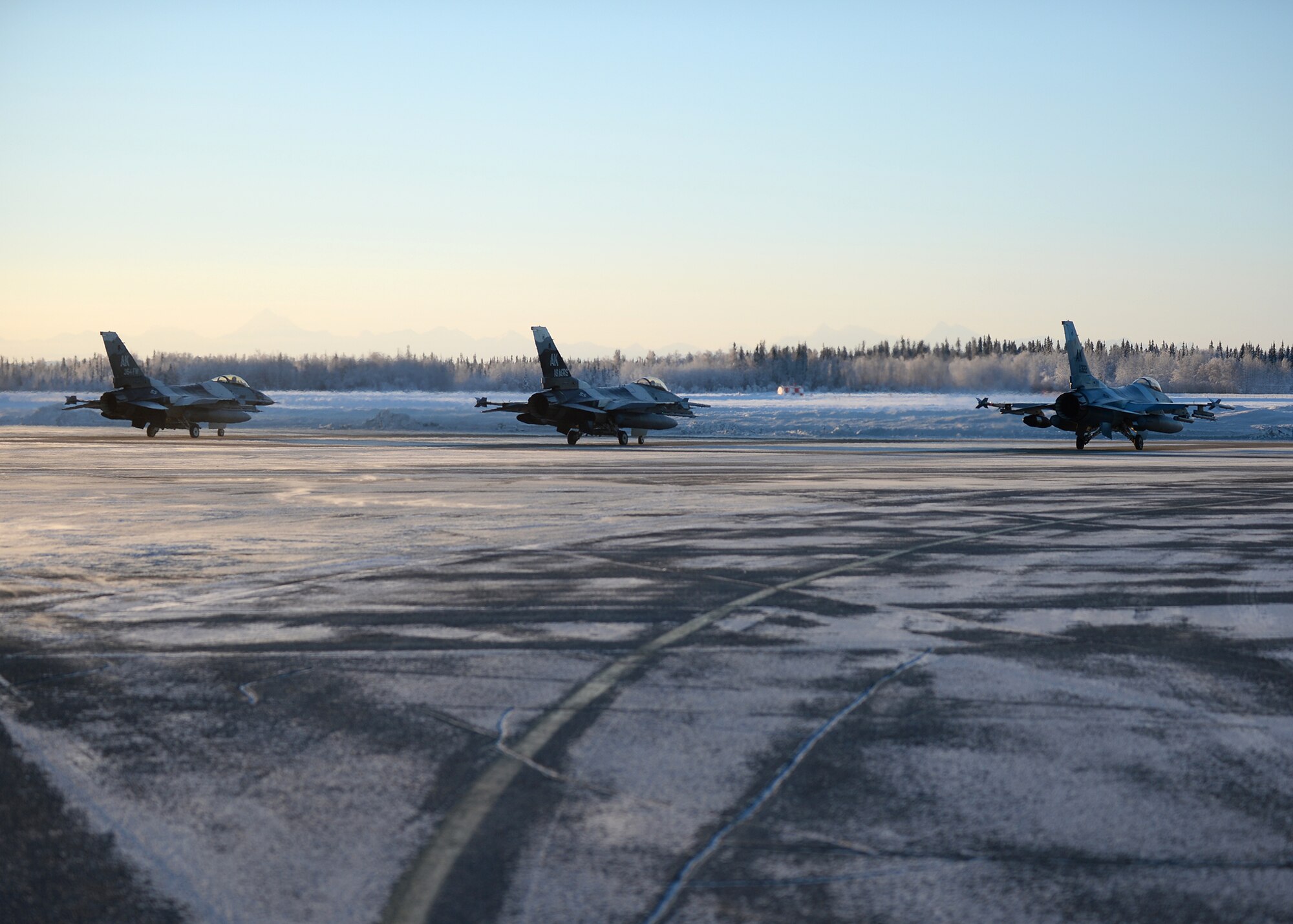 F-16 Fighting Falcons from the 18th Aggressor Squadron go through final checks prior to takeoff at Eielson Air Force Base, Alaska, Feb. 10, 2014. The squadron took off in the almost -40 degree weather flying to Anderson Air Force Base, Guam to support Cope North, a field-training exercise hosted by Pacific Air Forces. (U.S. Air Force photo by Senior Airman Shawn Nickel/Released)