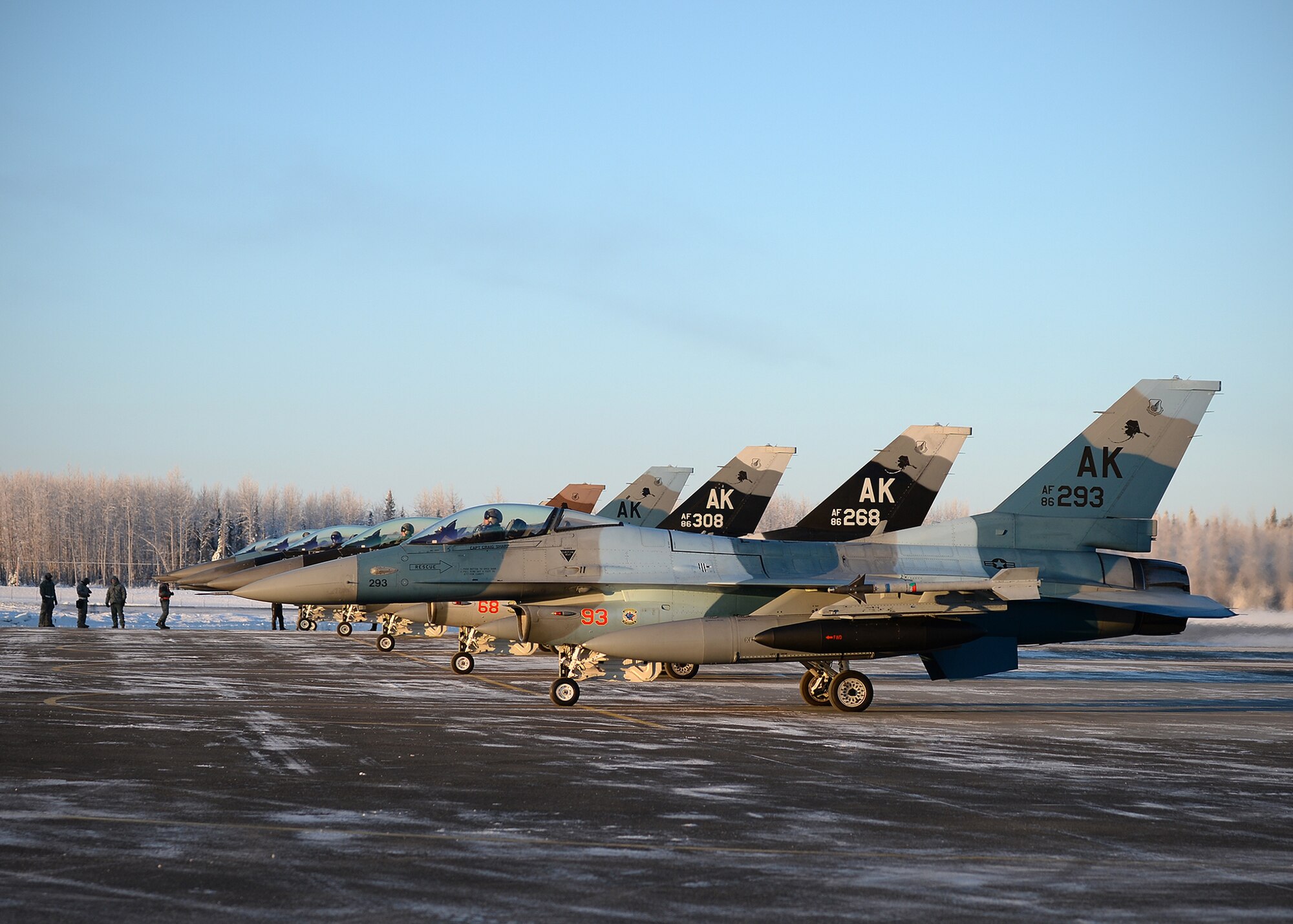 F-16 Fighting Falcons from the 18th Aggressor Squadron prepare for takeoff from Eielson Air Force Base, Alaska, Feb. 10, 2014. Ten Aggressors took off in succession to fly to Anderson Air Force Base, Guam to support Cope North, a field-training exercise hosted by Pacific Air Forces. (U.S. Air Force photo by Senior Airman Shawn Nickel/Released) 