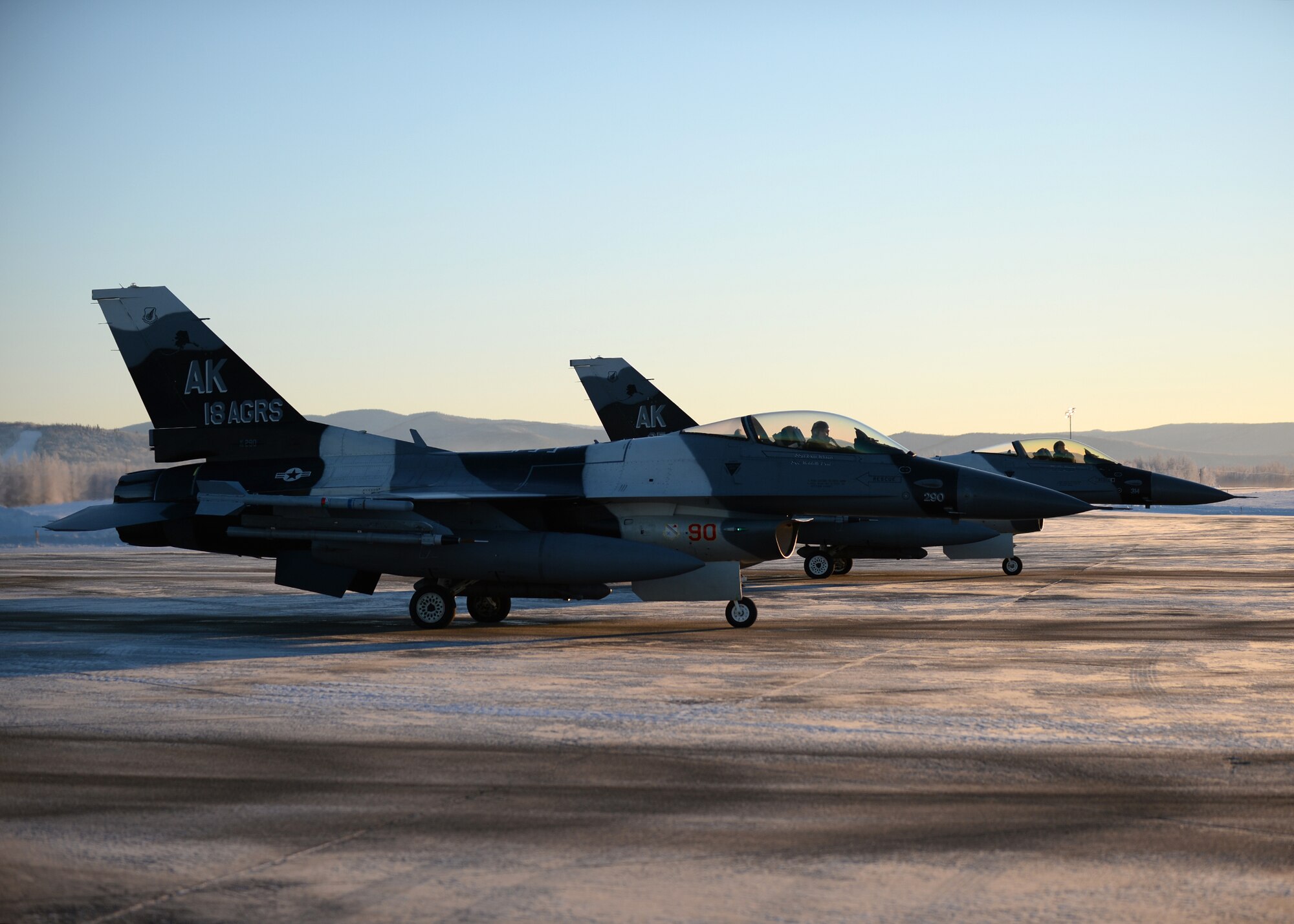 F-16 Fighting Falcons from the 18th Aggressor Squadron prepare for takeoff from Eielson Air Force Base, Alaska, Feb. 10, 2014. Ten Aggressors took off in succession to fly to Anderson Air Force Base, Guam to support Cope North, a field-training exercise hosted by Pacific Air Forces. (U.S. Air Force photo by Senior Airman Shawn Nickel/Released) 