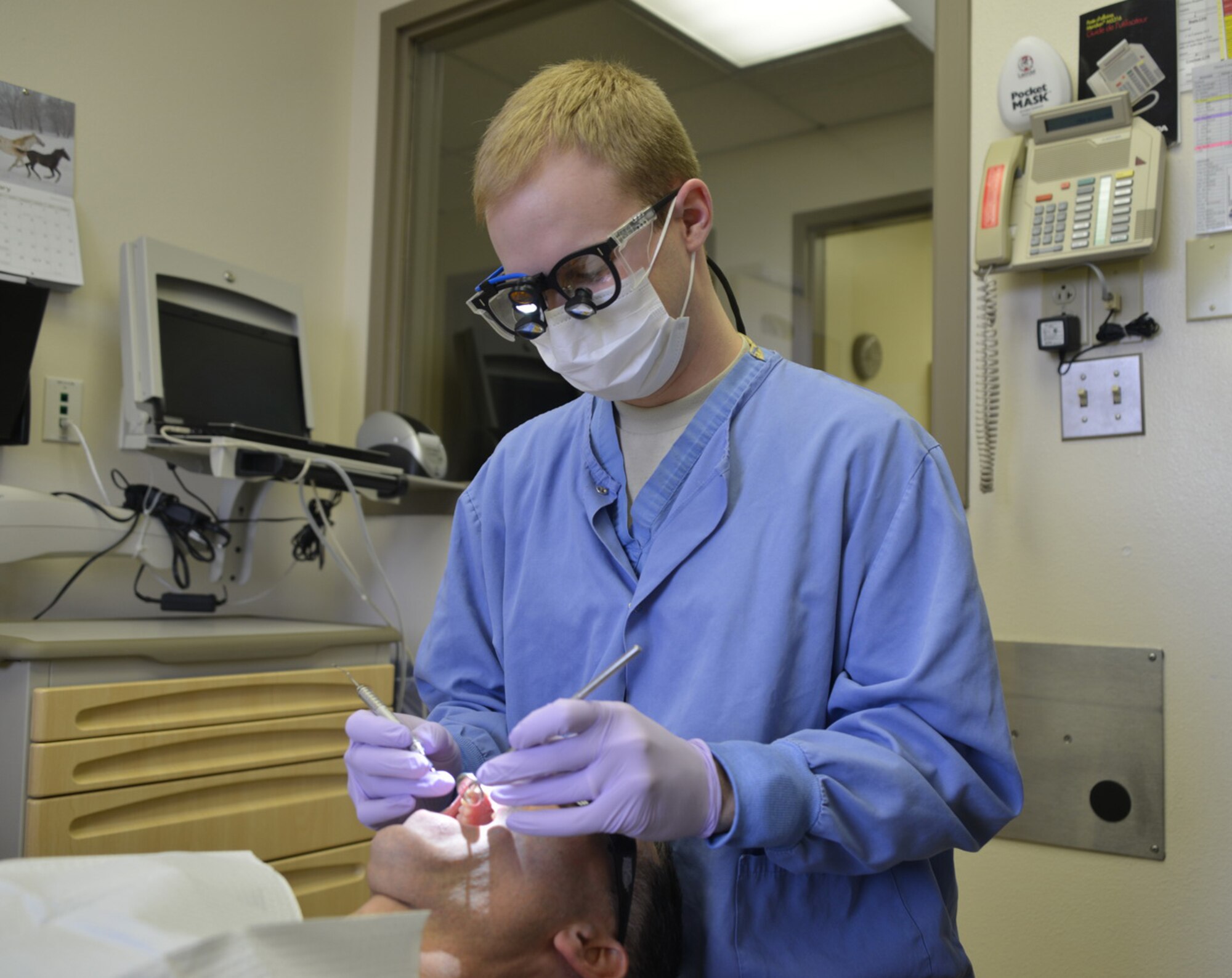 Capt. Austin Evans, 377th Dental Squadron, works on a patient at Kirtland's Dental Clinic. February is National Children's Dental Month which promotes awareness of the importance of children’s oral health. Members of the dental squadron will be giving demonstrations and discussing oral health topics throughout the month. (Photo by Todd Berenger)