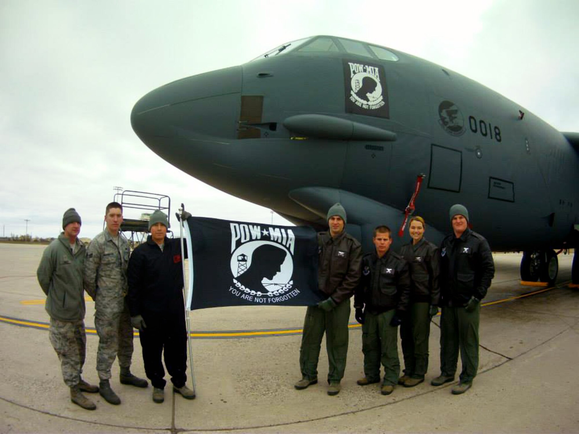 Staff Sgt. John M. Silva, 5th Aircraft Maintenance Squadron dedicated crew chief, and Capt. Joe Cangealose, 69th Bomb Squadron pilot, hold the POW/MIA flag in front of their B-52 at Minot Air Force Base, N.D., Nov. 4, 2013. The crews’ jet features the POW/MIA as its nose art. (Courtesy photo)