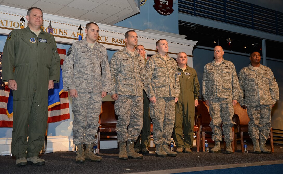 Maj. Gen. James Butterworth, left, adjutant general, Georgia National Guard, prepares to present the Georgia Meritorious Service Medal to three Guardsmen from the 116th Security Forces Squadron, L-R, Master Sgt. Richard Ross and Tech. Sgts. Dominick Andrews and Timothy White, during a ceremony at the Museum of Aviation, Century of Flight hangar, Robins Air Force Base, Ga., Feb. 9, 2014. The three Guardsmen performed life saving CPR procedures on a fellow passenger while aboard a commercial flight in route to pre-deployment training. (U.S. Air National Guard photo by Master Sgt. Roger Parsons/Released) 