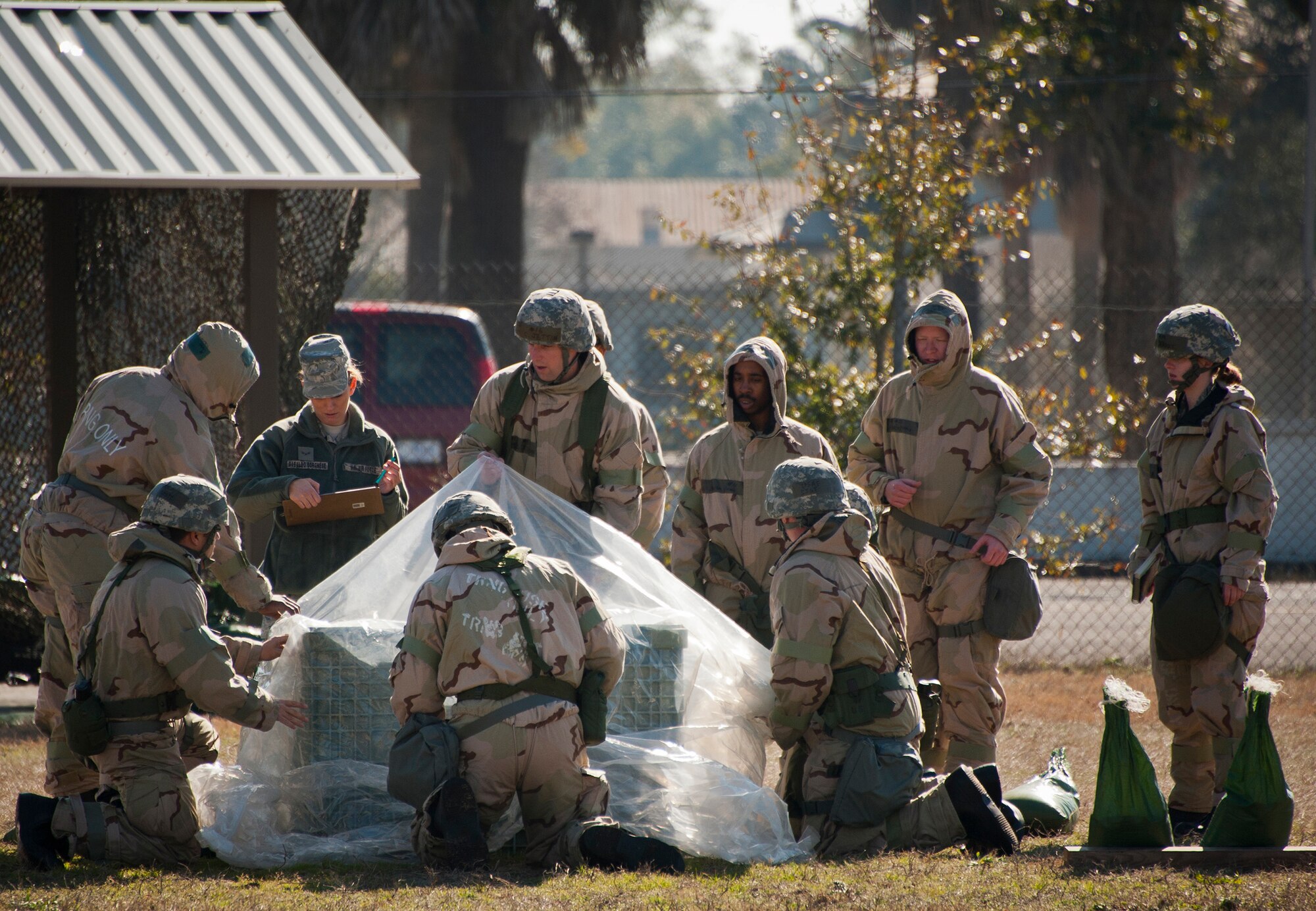 Airmen learn to cover a valuable asset as part of contamination avoidance measures during the field training portion of a Phase II exercise Feb. 7 at Eglin Air Force Base, Fla. A Phase II evaluates an Airman’s ability to meet wartime and contingency taskings of employing the force, sustaining the force and the ability to survive and operate. More than 70 potential deployers received the classroom and practical field training during a series of 96th Test Wing exercises occurring all week. (U.S. Air Force photo/Sara Vidoni)