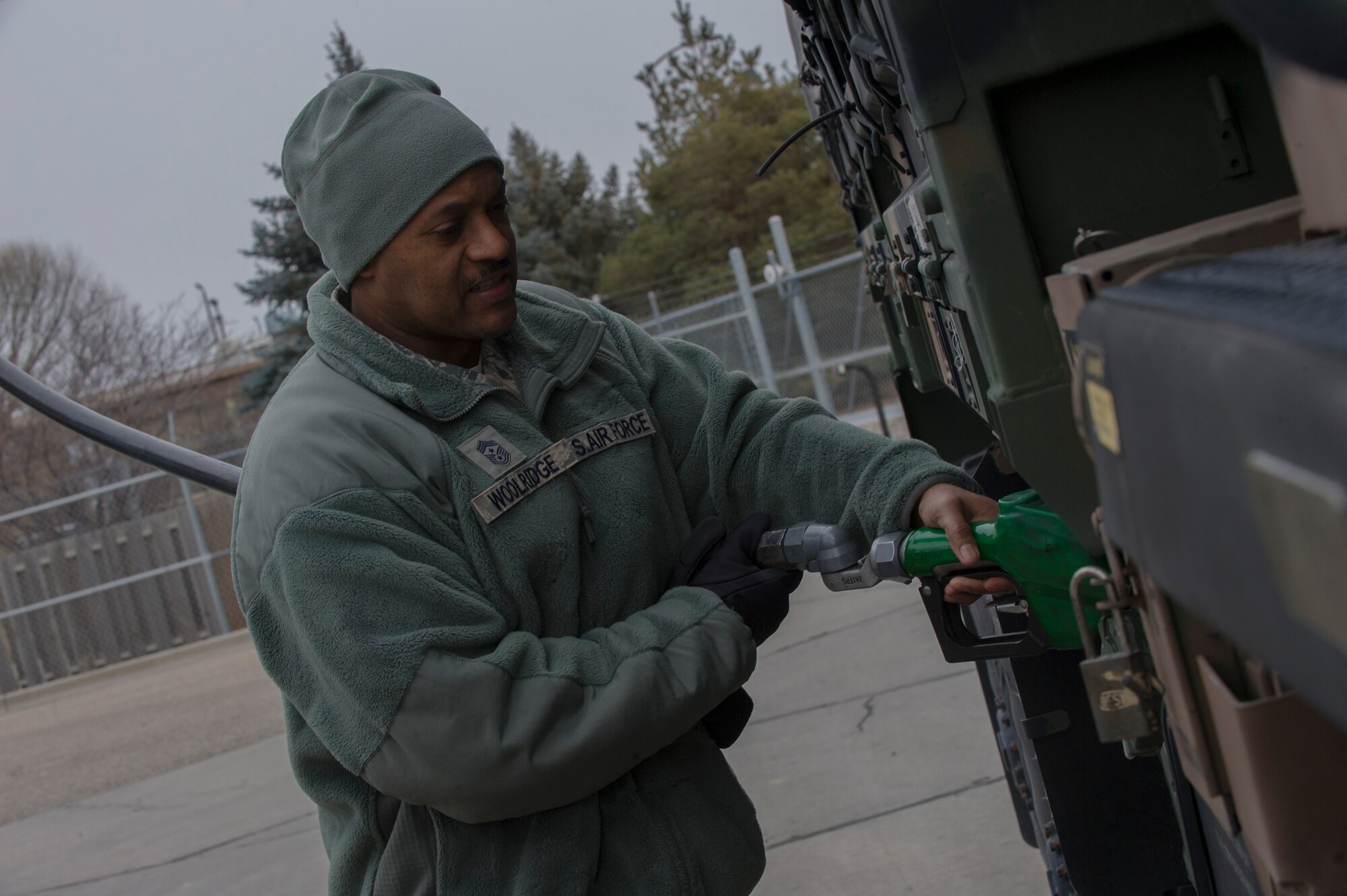 U.S. Air Force Chief Master Sgt. Avery Woolridge, 552nd Air Control Wing command chief, fills the gas tank on a K251 5-ton truck during a site visit with the 726th Air Control Squadron at Mountain Home Air Force Base, Idaho, Feb. 5, 2014. The 726th ACS is responsible for mobile, decentralized command and control of joint operations by conducting threat warning, battle management, theater missile defense, weapons control, combat identification and strategic communications. (U.S. Air Force photo by Staff Sgt. Roy Lynch/Released)