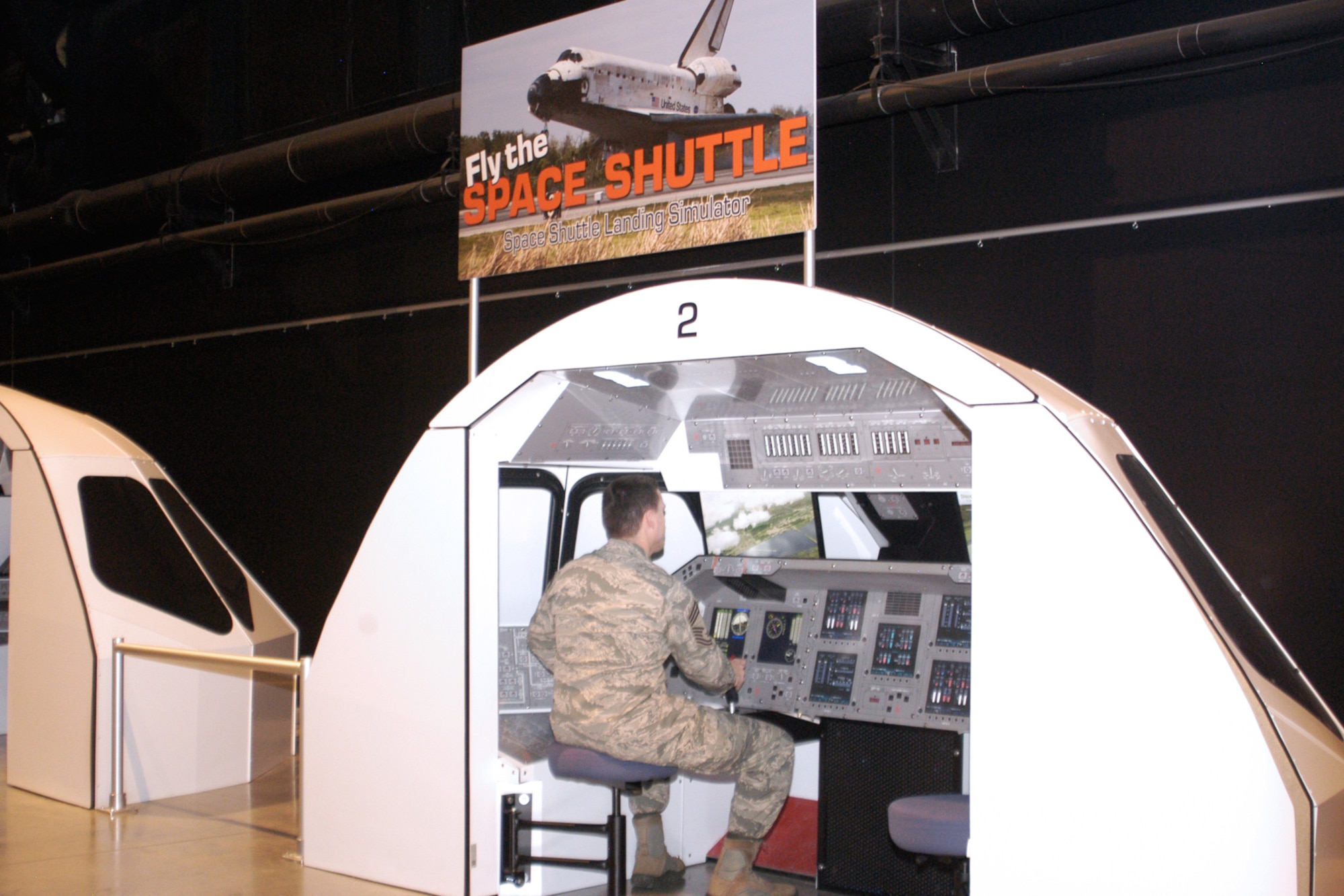 National Museum of the U.S. Air Force visitors can test their skill at landing a space shuttle orbiter with the interactive space shuttle landing simulators. The simulators are free of charge and allow visitors to “fly” the shuttle to a safe landing using a joystick and video screens, and receive feedback on how well they piloted the shuttle. (U.S. Air Force Photo)