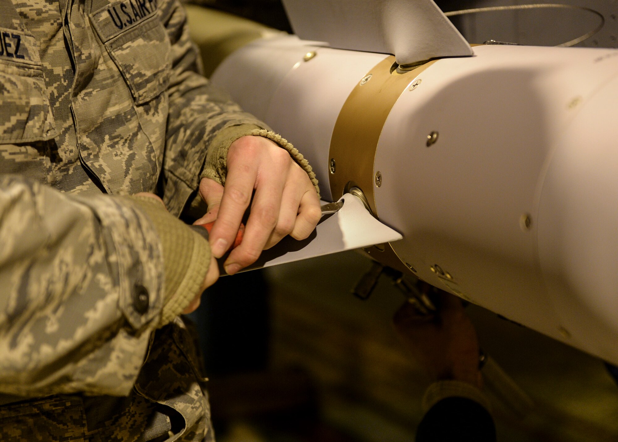 Staff Sgt. Angelo Rodriguez, 492nd Fighter Squadron weapons load crew team chief, tightens the fins on a Guided Bomb Unit 12 in a protective aircraft shelter at Royal Air Force Lakenheath, England, Feb. 7, 2014. The 492nd FS is participating in the first-ever ammunitions flight training exercise at RAF Lakenheath. (U.S. Air Force photo by Airman 1st Nigel Sandridge/Released)