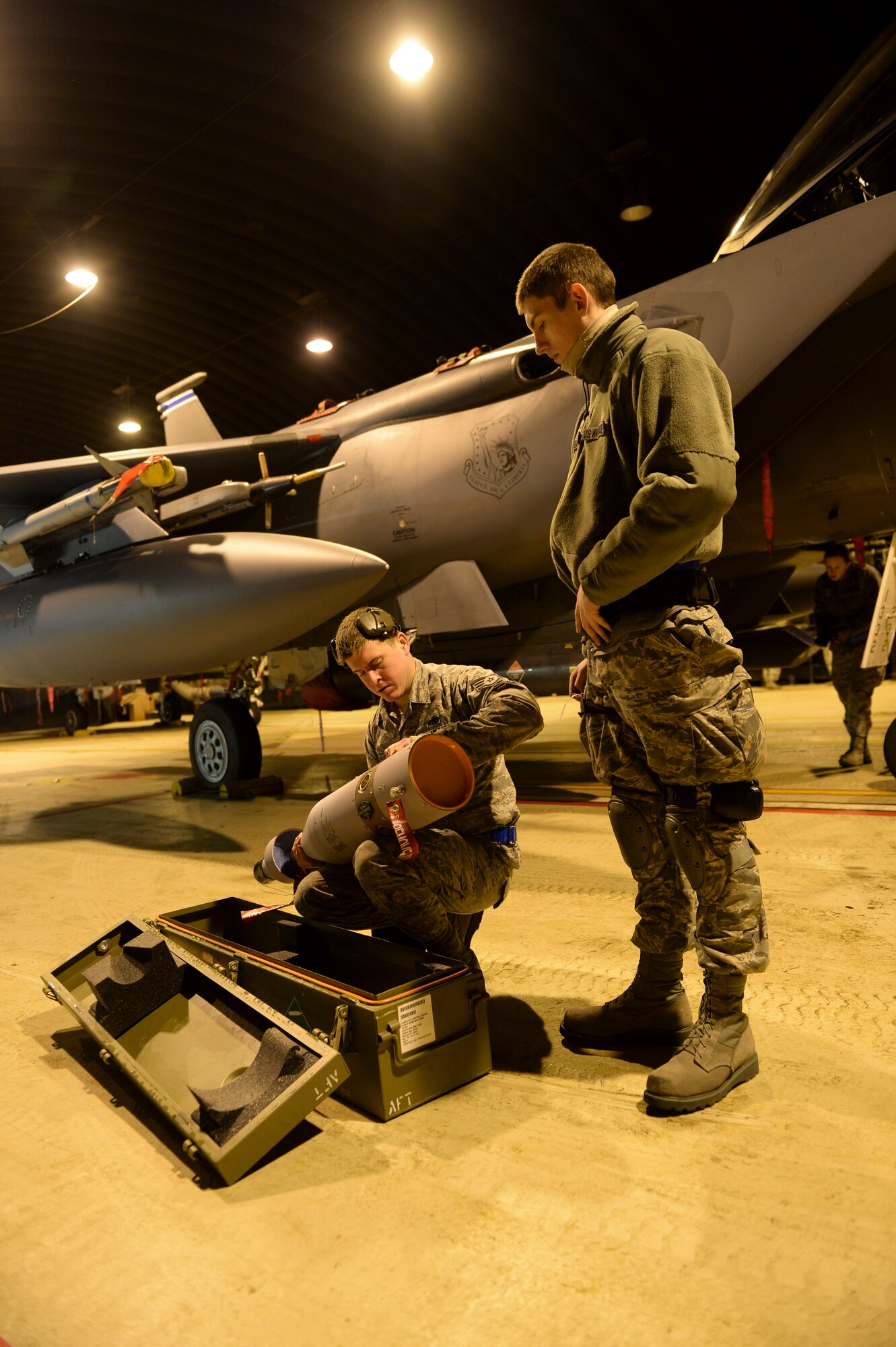 Staff Sgt. Angelo Rodriguez, 492nd Fighter Squadron weapons load crew team chief, demonstrates how to properly inspect a Guided Bomb Unit 12 to Airman 1st Class Justice Redd, 492nd FS weapons load crew apprentice, in a protective aircraft shelter at Royal Air Force Lakenheath, England, Feb. 7, 2014. The 492nd FS is participating in the first-ever live ammunition flight-training exercise at RAF Lakenheath. (U.S. Air Force photo by Airman 1st Nigel Sandridge/Released)