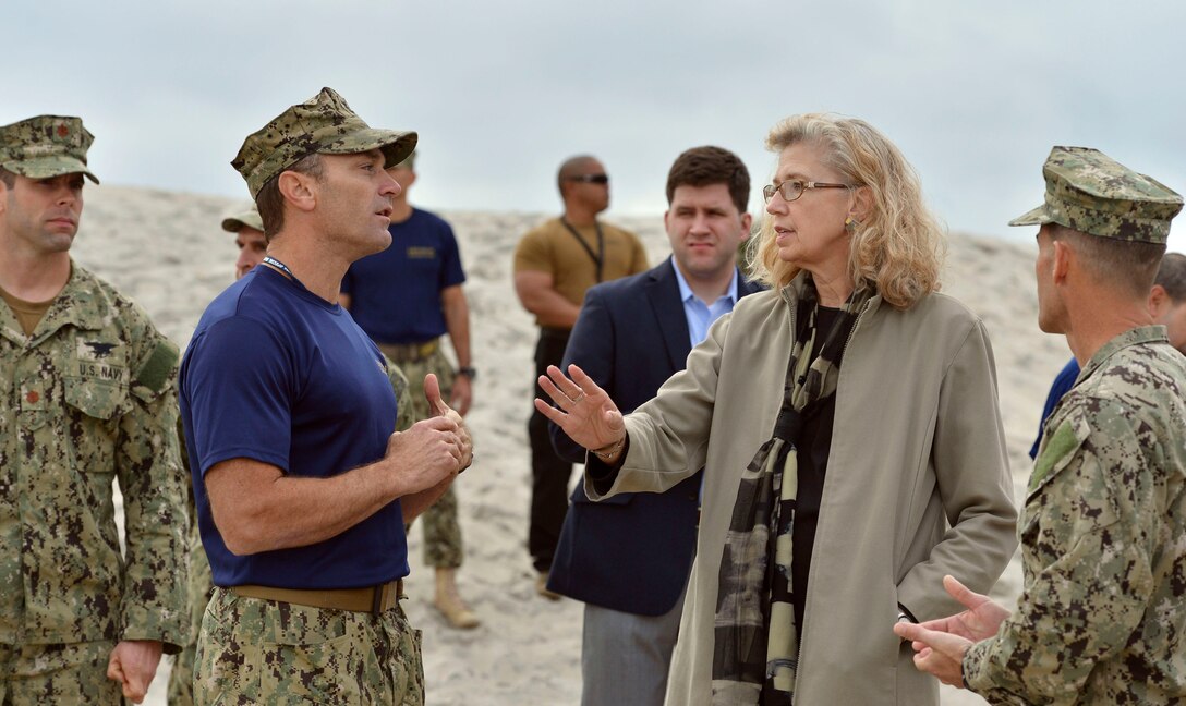 Acting Deputy Defense Secretary Christine H. Fox gets a briefing from Navy Master Chief Petty Officer Paul Baden as she tours SEAL Beach, named after the Navy's special operations force, at the Navy Special Warfare Center in San Diego, Feb. 10, 2014.