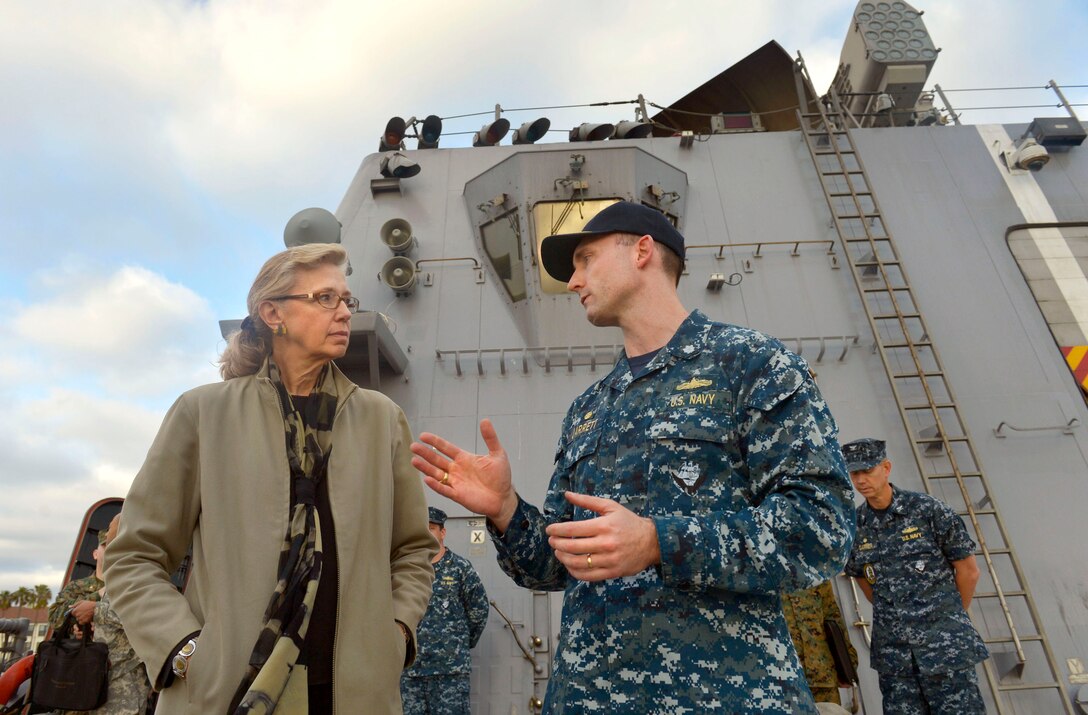Acting Deputy Defense Secretary Christine Fox listens as Navy Cmdr. Michael R. Jarrett Jr., commanding officer of the USS Freedom, gives her a tour of the ship in San Diego, Feb. 10, 2014. 