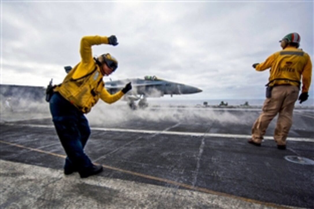 U.S. Navy Petty Officer 2nd Class Ted Casal checks the shot line before launching an F/A-18C Hornet from Strike Fighter Squadron 94 aboard the aircraft carrier USS Carl Vinson in the Pacific Ocean, Feb. 7, 2014. The Vinson is training off the coast of Southern California. 