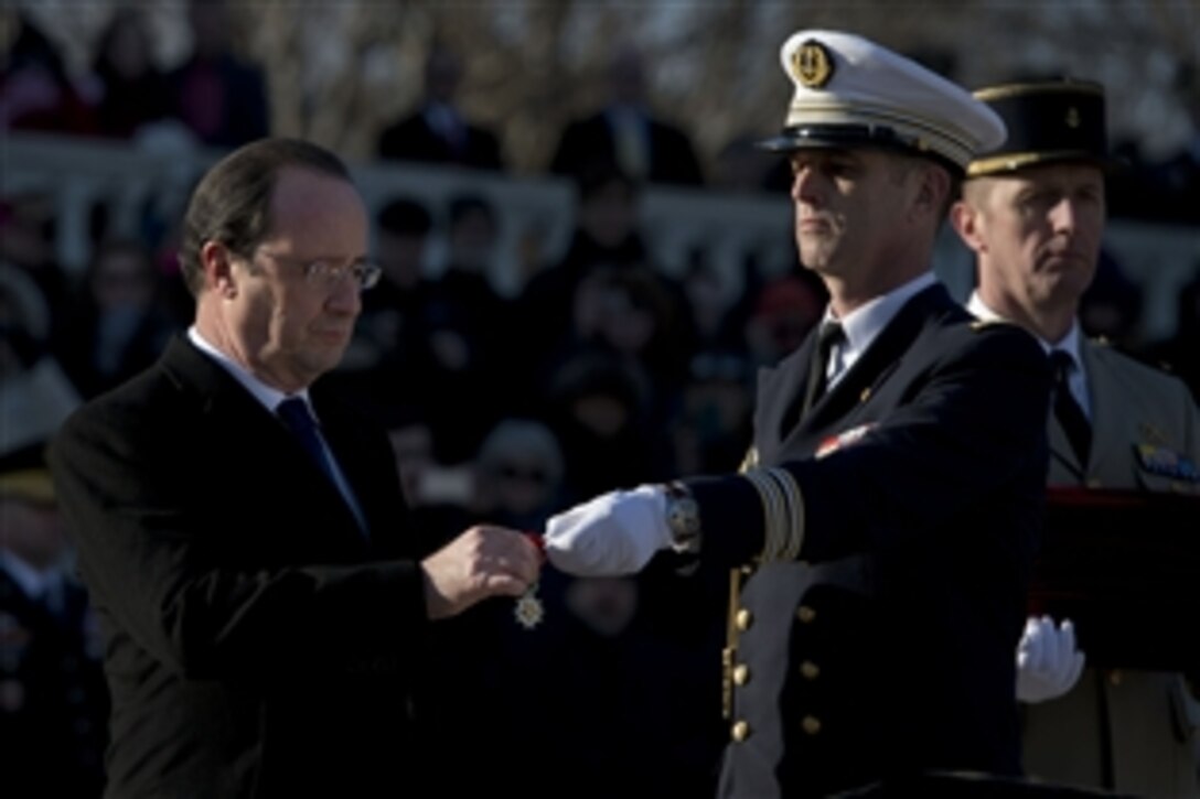 French President Francois Hollande presents the World War II Unknown with the French Legion of Honor, France's highest military award, at the Tomb of the Unknowns at Arlington National Cemetery in Arlington, Va., Feb. 11, 2014. U.S. Defense Secretary Chuck Hagel, who participated in the ceremony, thanked Hollande for the honor.  