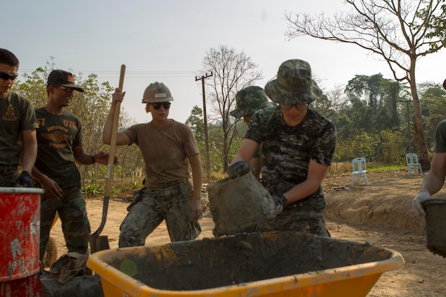 Republic of Korea Cpl. Kim Seungju dumps wall plaster into a wheel barrow as U.S. Navy Petty Officer 3rd Class Shianne M. Chlupacek observes Feb. 10 at Wut Khun Song school near Ban Chan Krem, Kingdom of Thailand. U.S. service members joined forces with Royal Thai Marines and Republic of Korea Marines for a community relations project which started Jan. 25 and is expected to be completed Feb. 20. The program is part of Exercise Cobra Gold 2014, a multinational and multiservice exercise that takes place annually in the Kingdom of Thailand and was developed by the Thai and U.S. militaries. Seungju is a combat engineer with 1st Engineer Battalion, ROK Marine Division. Chlupacek is a steelworker with Seabees’ Naval Mobile Construction Battalion 3, 1st Naval Construction Group.