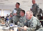 Left to right, Maj. Chuck Reinhold, Lt. Col. David Jones, Brig. Gen. Timothy E. Gowen, Col. William Coffin and Col. Brent Johnson (standing) conduct a briefing Jan. 23, 2014, at the Joint Multinational Readiness Center in Hohenfels, Germany.